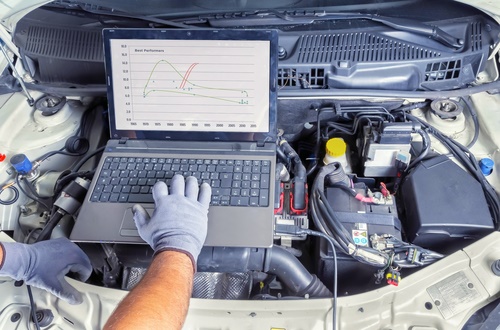 Professional car mechanic working in auto repair computer service