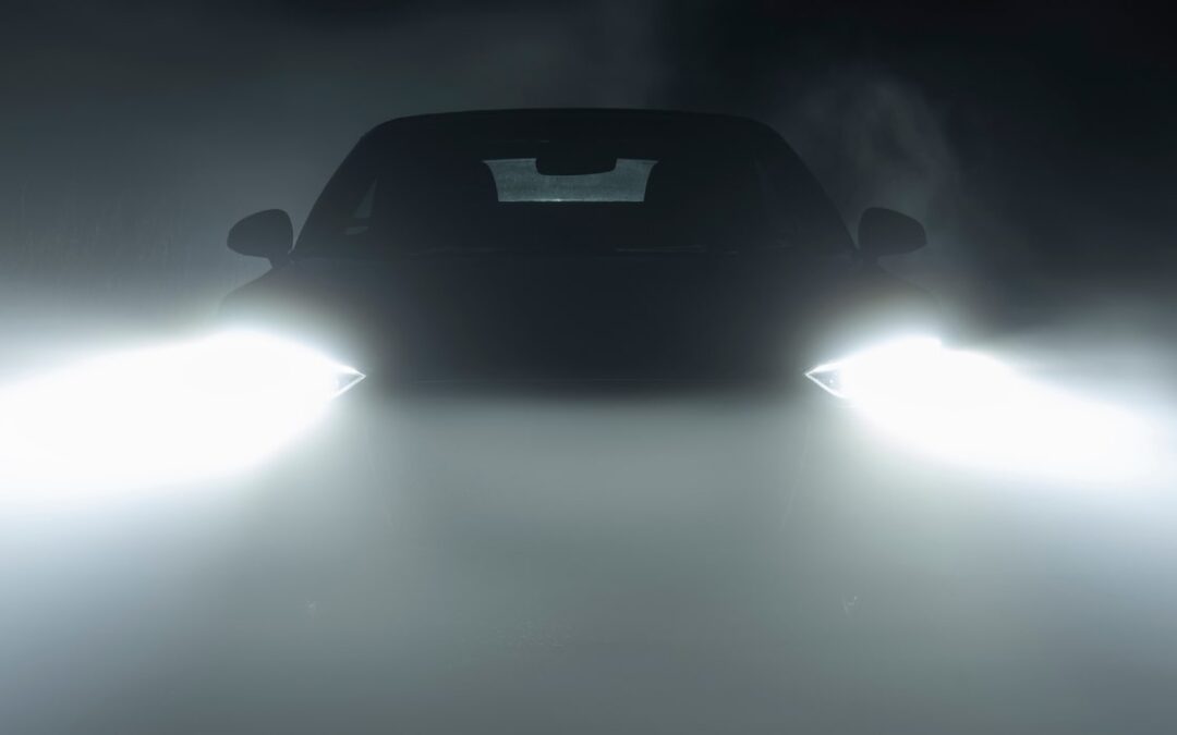 car with headlights on in the fog at night