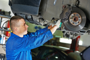Technician inspecting brakes inside autoshop