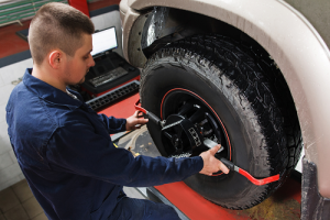 Technician aligning vehicle wheel